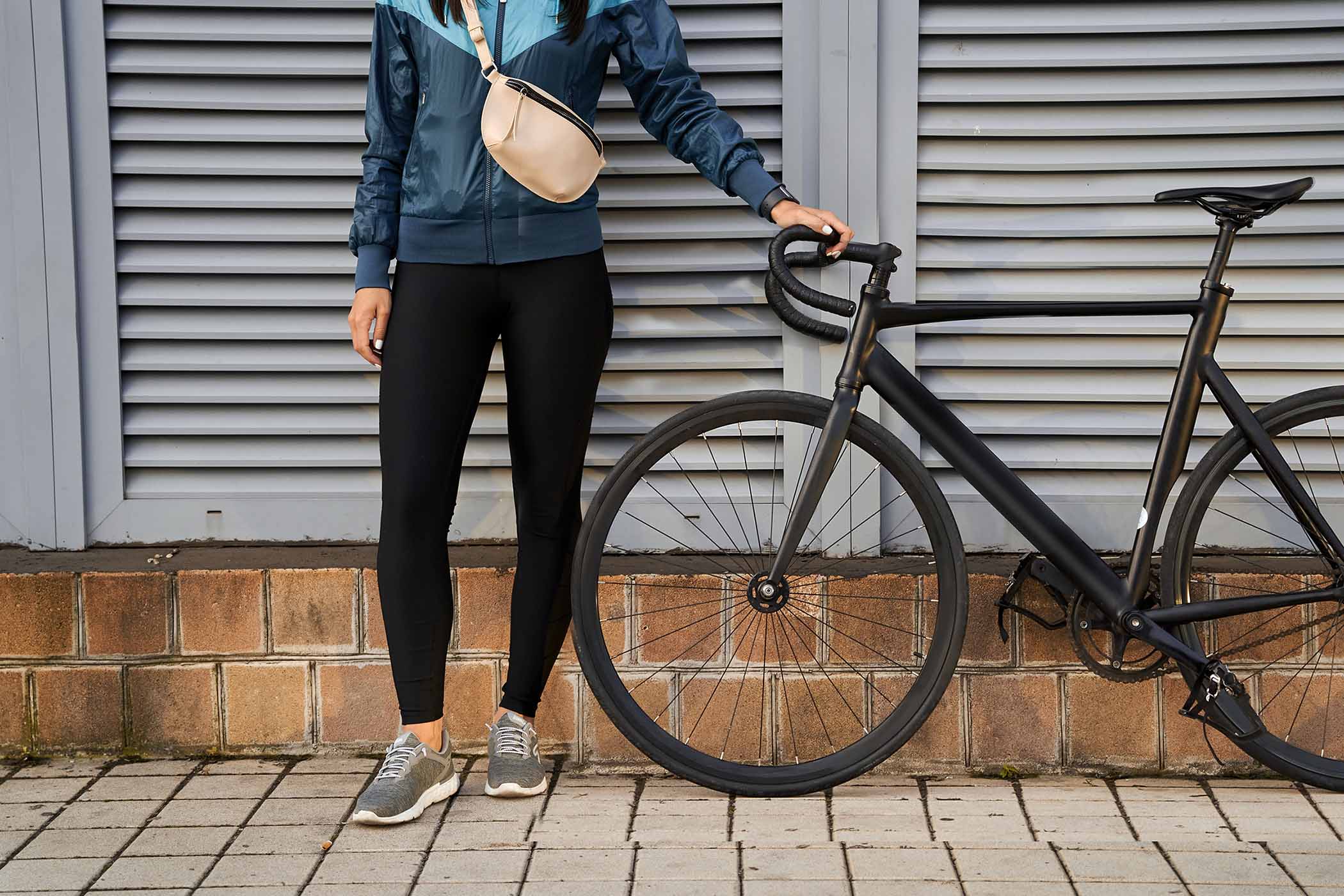 lady-in-black-leggings-holding-the-bicycle-handleb-7UA8XU4.jpg